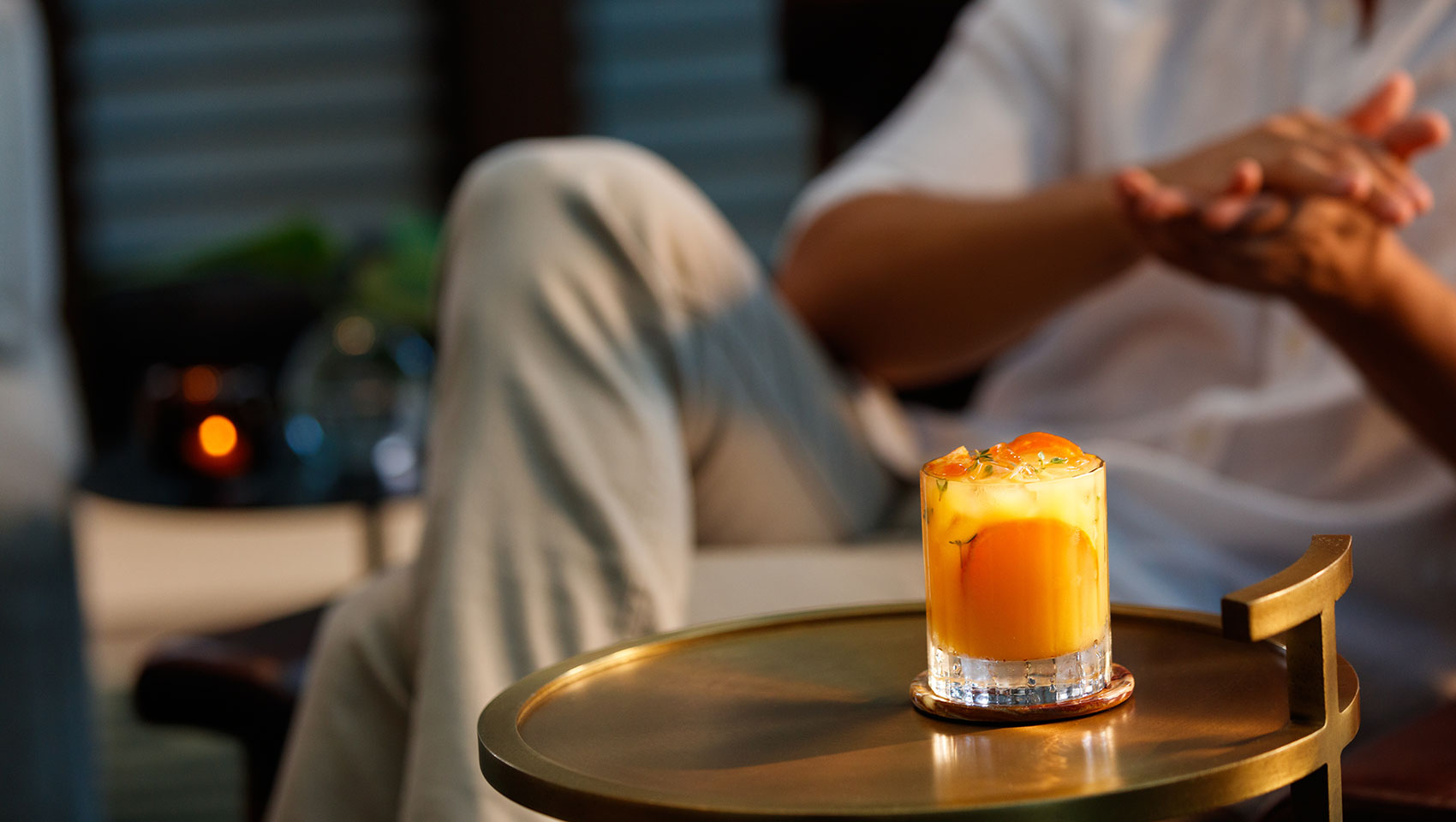 cocktail on table with man sitting in chair in background