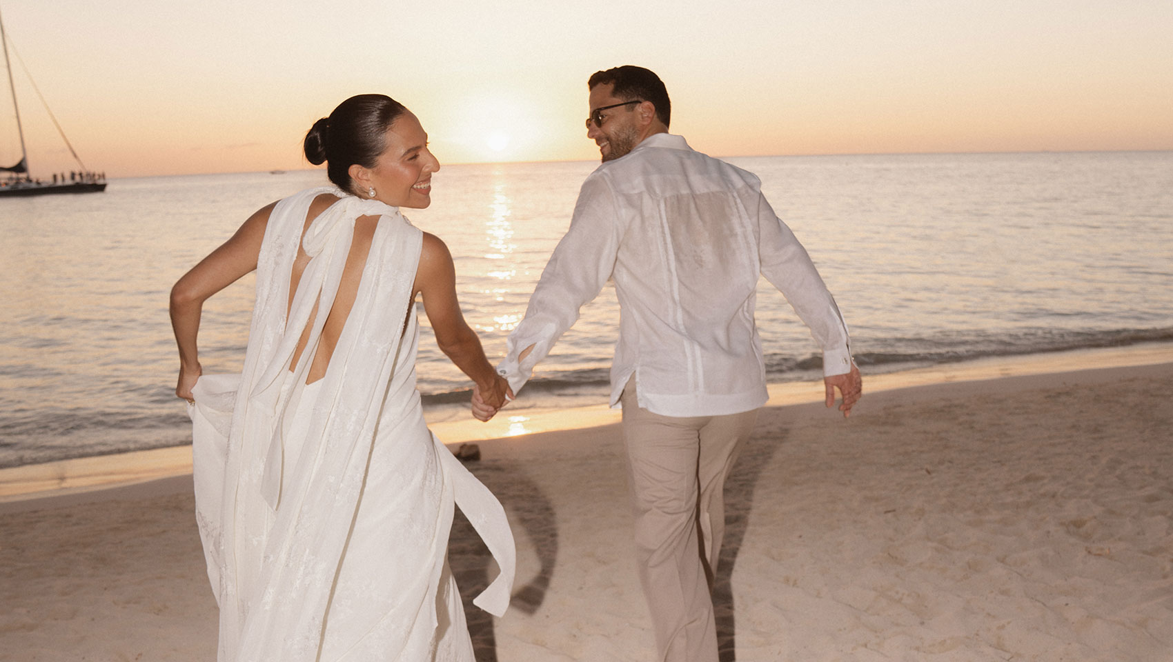 Bride and groom run on the beach at Kimpton Grand Roatan