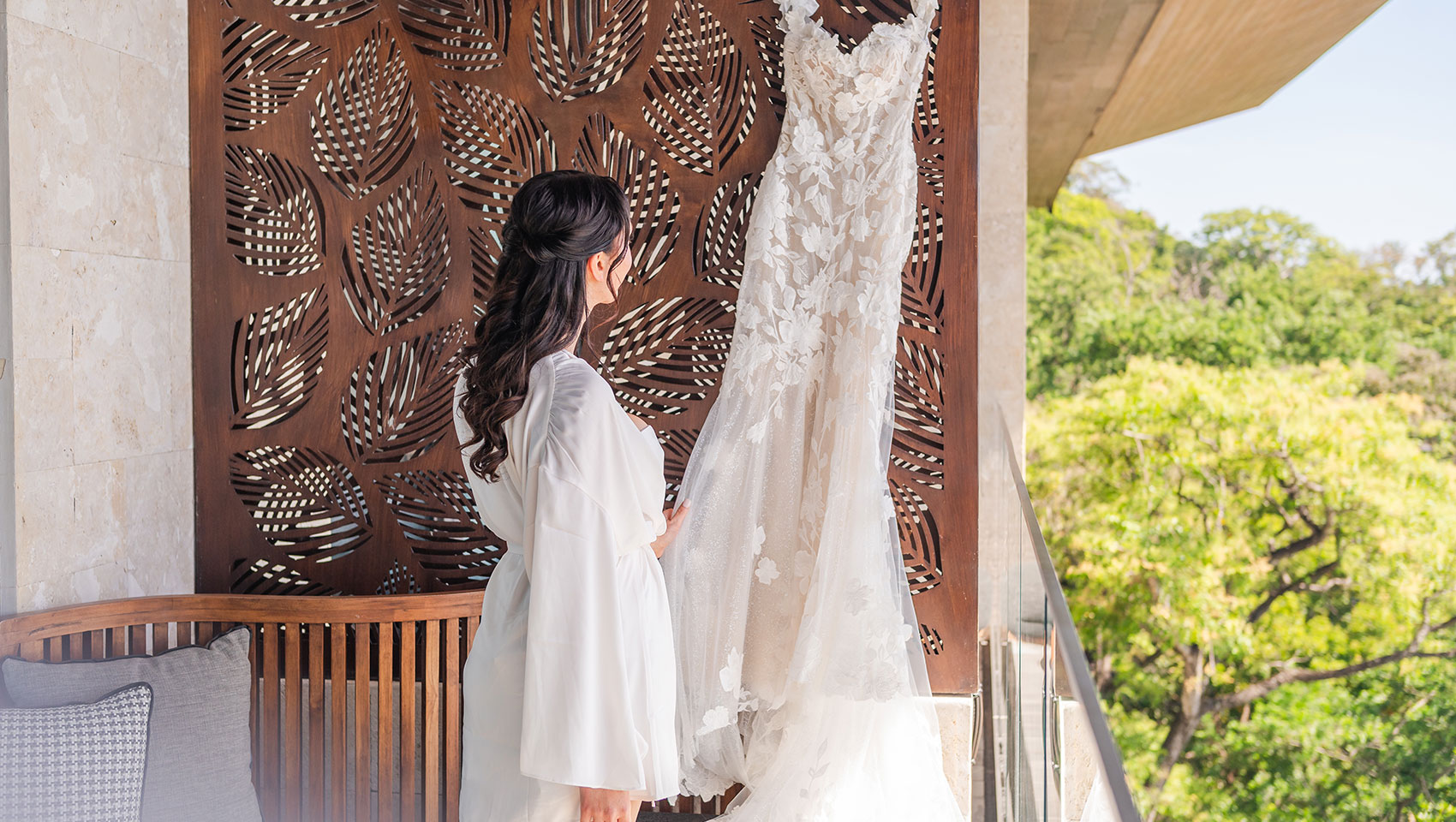 Bride looking at her dress on balcony at Kimpton Grand Roatan