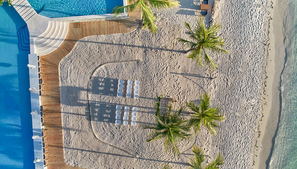 Overhead drone shot of Roatan beach with wedding chairs set-up