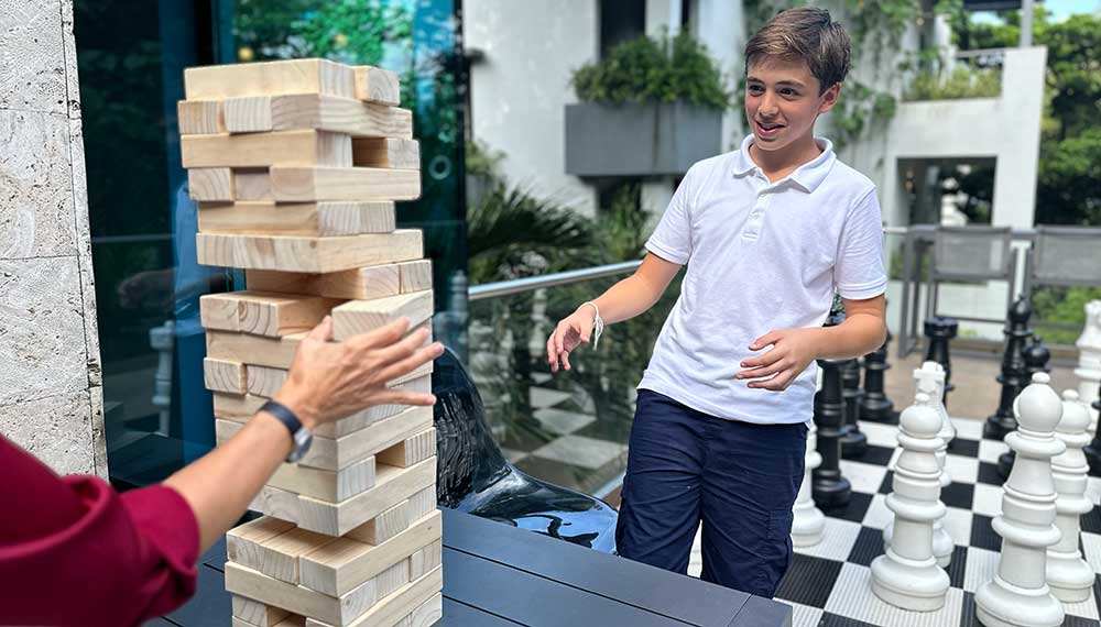 Boys playing life-size Jenga at  Kimpton Grand Roatan