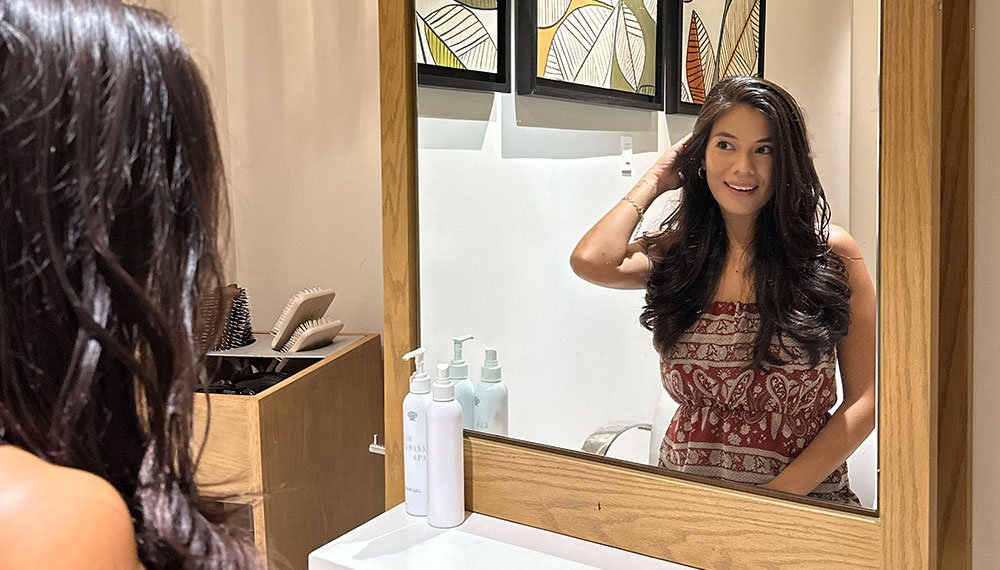 Woman looking in mirror admiring her hair