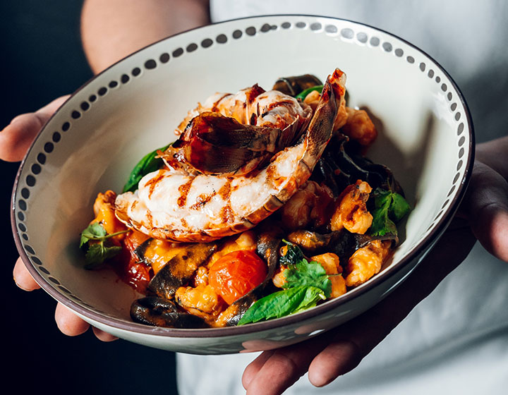 Chef holding lobster dish