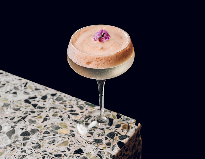 Cocktail with purple flower garnish