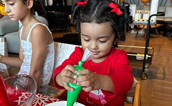 Kimpton Grand Roatan child guest decorating a holiday cookie
