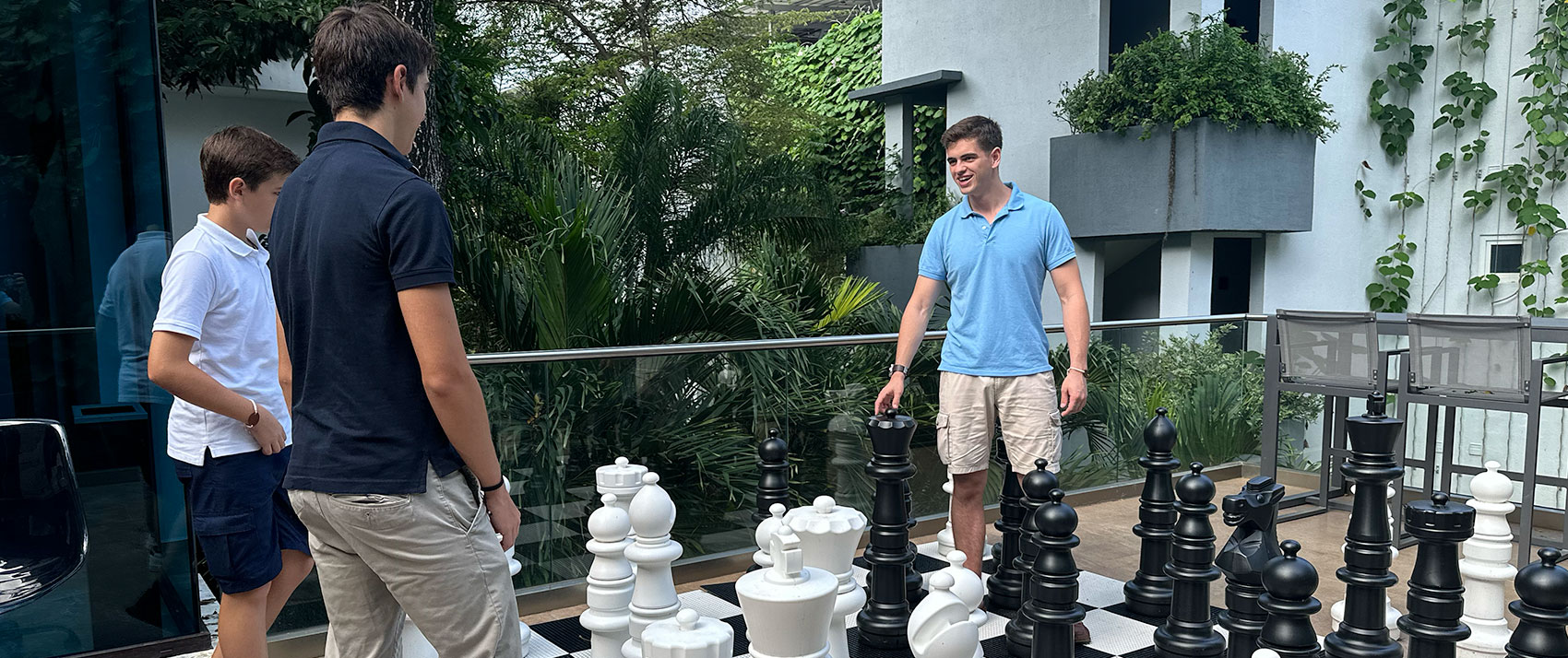 3 boys playing life-size chess